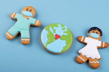 Gingerbread boy and girl in a mask on blueの写真素材