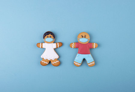 gingerbread boy and girl in a mask on blueの写真素材