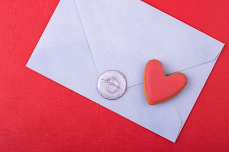 blue envelope with a wax stamp of love and a red heart on a red background. love letter, background...