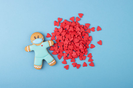 gingerbread medic in a mask and a lot of small hearts on a blue background. the day of the doctor, Valentine's dayの写真素材