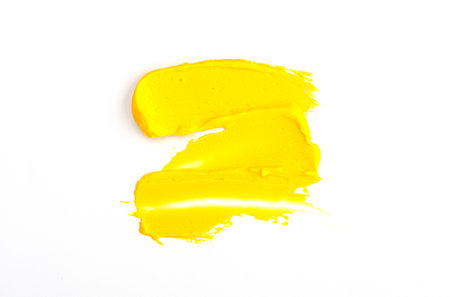 a spot of yellow oil paint isolated on a white background. yellow for 2021の写真素材