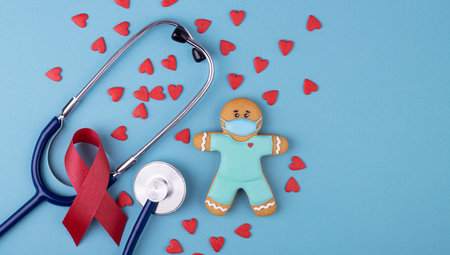 red ribbon for fighting AIDS on a blue background. phonendoscope with small red heartsの写真素材