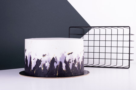 beautiful black and white cake on a white table. cake for a holiday and birthdayの写真素材