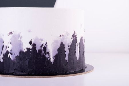 beautiful black and white cake on a white table. cake for a holiday and birthdayの写真素材