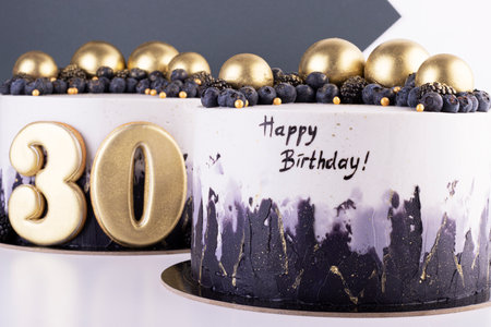 Festive black and white cakes 30 years old with golden balls and dark berries. birthday and anniversary cakeの写真素材