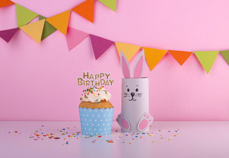 cute rabbit made of handmade paper with a small cake and the inscription happy birthday. celebration, celebration with confettiの写真素材