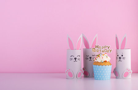 Cute paper rabbits from a roll of toilet paper with the cake on his birthday. Background for the birthday party. children's holidayの写真素材