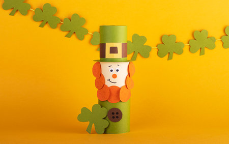 Leprechaun made of handmade paper with green four-leaf clover on the background. Cultural and religious holiday St. Patrick's dayの写真素材