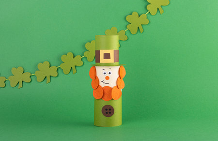 Green cute Leprechaun made of handmade paper with four-leaf clover on a green background, space for text. Cultural and religious holiday St. Patrick's dayの写真素材