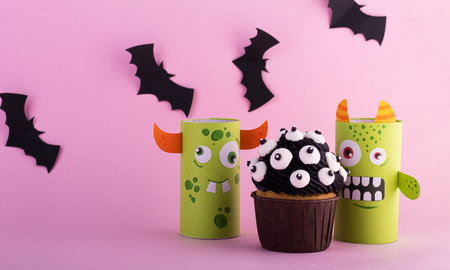 paper ghosts with a mystical cupcake for Halloween. Creative Halloween background with sweetsの写真素材