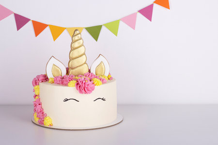 beautiful delicate unicorn birthday cake on a white tableの写真素材