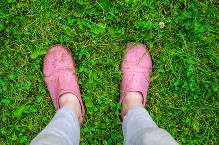 feet in garden shoes on green grass