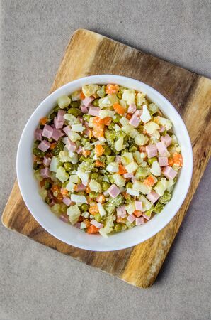 Russian salad Olivier carrot green peas on the board and gray backgroundの写真素材