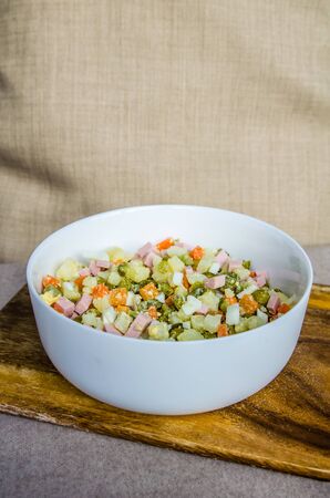 Russian salad Olivier carrot green peas on the board and gray backgroundの写真素材