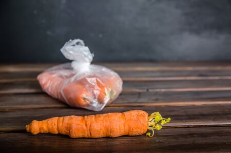 concept plastic free carrots in a plastic bag on a brown background with copy spaceの写真素材