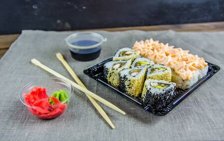 delivery of rolls at home. Rolls in a box. Sticks, soy sauce.の写真素材