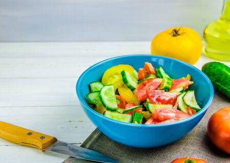 summer salad with cucumbers and tomatoes on white background with copy spaceの写真素材
