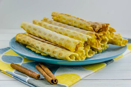 homemade waffle tubes on a blue plate on white backgroundの写真素材