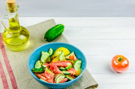 summer salad with cucumbers and tomatoes on white background with copy spaceの写真素材