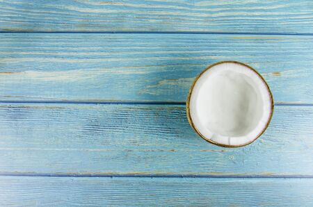 split coconut lies against a blue backgroundの写真素材