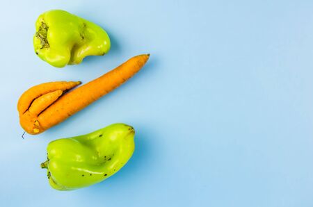 ugly food. green peppers and carrots on a blue background