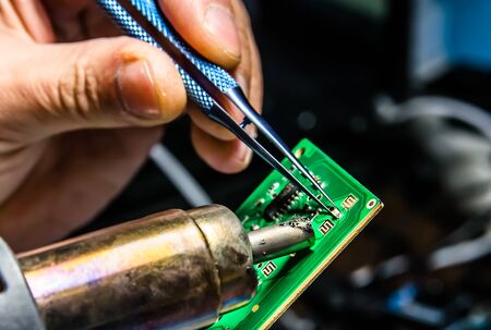 Technical support worker drops the fee PCB. Soldering iron. Tweezersの写真素材