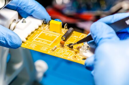 Technical support worker drops the fee PCB. Soldering iron. Tweezersの写真素材