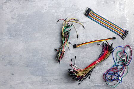 electrician, electronics. different wires on a gray wooden background. Place for text. top view,...