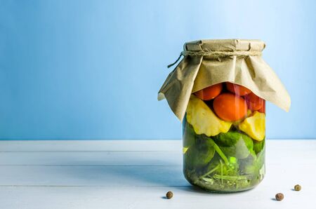pickled vegetables. cucumbers, tomatoes, patissons on blue background with copy spaceの写真素材