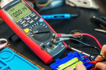 technical master tests the battery voltage. battery, wires. technical support, repairの写真素材