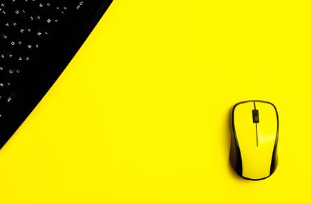 flat lay workspace black keyboard, yellow computer mouse, yellow background. copy spaceの写真素材