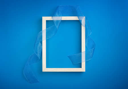 frame with blue ribbon on a blue backgroundの写真素材