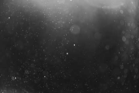 snow or rain bokeh texture overlay on black background.