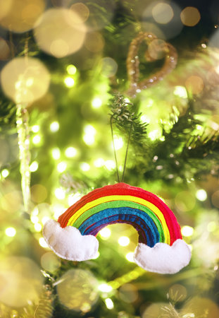 New Years rainbow toy on a Christmas tree with garlands.の写真素材