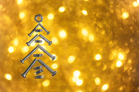 Christmas tree of bolts on a golden backgroundの写真素材
