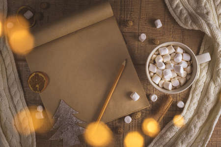 Christmas new year concept with cup of coffee with marshmallows and notepad. with copy space. scarf,...