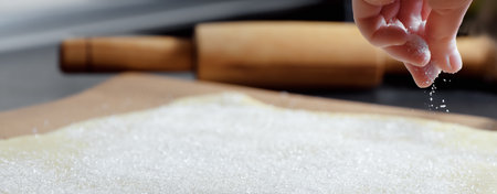 kids hand sprinkles sugar dough on the table