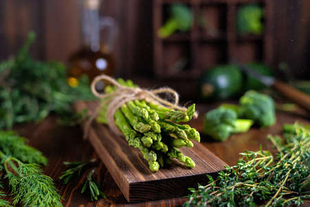 Fresh wild asparagus tied with rope in the kitchen, selective focus. vegetarian, healthy, raw foodの写真素材
