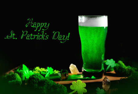 St. Patrick's Day Green Beer pint over wooden background, with shamrock leaves, harp. Patrick Day...