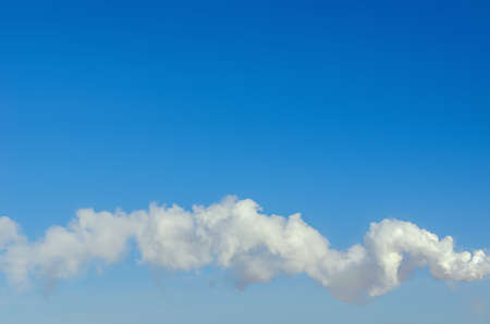 smoke from the chimney against the blue skyの写真素材