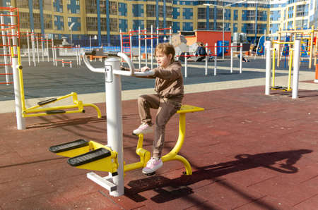 Adorable little kid girl making exercises on sports training apparatus at the gymの写真素材