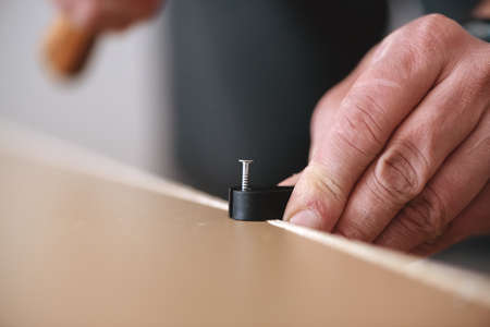 Master man hammers a nail into furnitureの写真素材