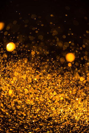 gold sequins fall on a black backgroundの写真素材
