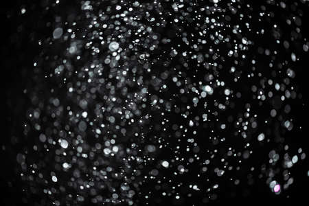 snow or rain bokeh texture overlay on black background.の写真素材
