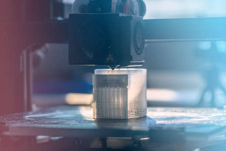 The 3D printer prints white transparent plastic modelの写真素材