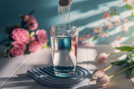 Collagen powder is add to glass of water with a spoon