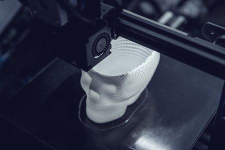 The 3D printer prints white plastic model