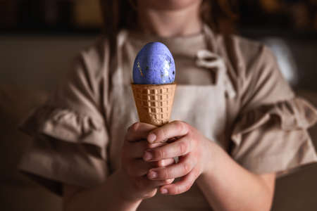 girl holding an Easter egg in a colored ice cream cone