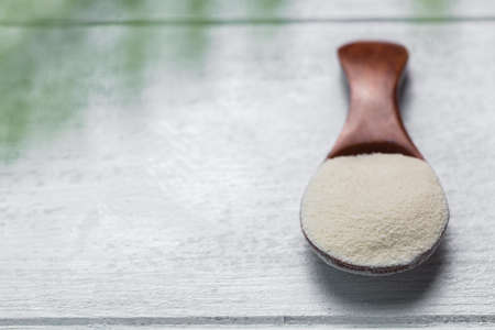 Collagen powder in spoon on wooden white background.の写真素材