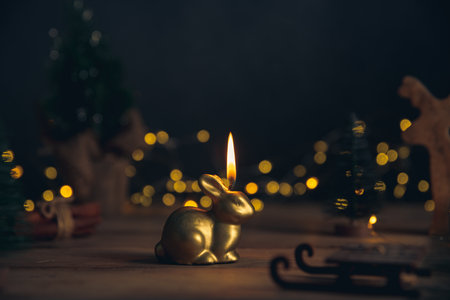candle in the form of a rabbit symbol of 2023 among the lights, garlands, Christmas trees, chinese calendar year symbolの写真素材